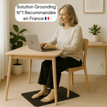 Femme assise au bureau avec tapis grounding